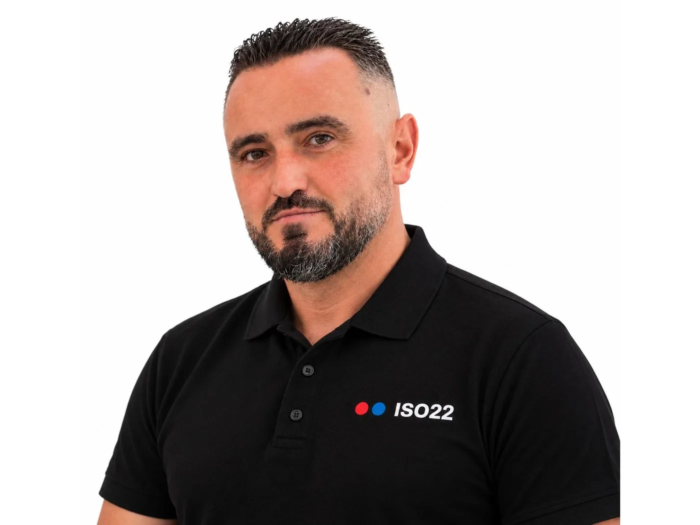 Safet Alushaj, Inhaber der ISO22 GmbH, im Poloshirt mit ISO22-Logo